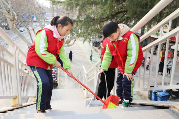 市三实小志愿者11年义务扫马路天桥